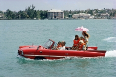 Slim Aarons, Sea Drive, 1967: Film producer Kevin McClory takes his wife Bobo Segrist and their family for a drive in an "Amphicar" across the harbor at Nassau